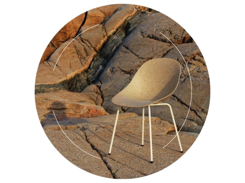 Normann Copenhagen's Mat chair made from recycled hemp, shown resting on a rocky cliff. On top of the image, thin black lines form a circle, highlighting an example of circular design in the furniture industry.