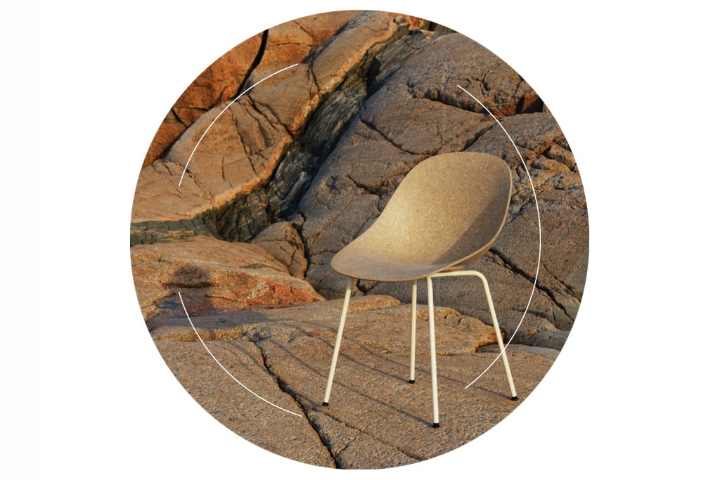 Normann Copenhagen's Mat chair made from recycled hemp, shown resting on a rocky cliff. On top of the image, thin black lines form a circle, highlighting an example of circular design in the furniture industry.