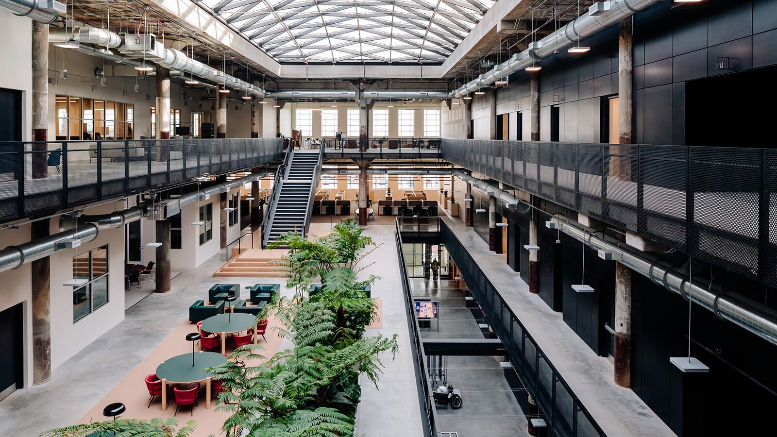 The double-height atrium resolves a key design challenge: bringing light into the centre of the building’s deep square floor plate.