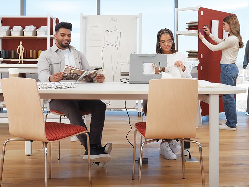 Two students work at a white desk