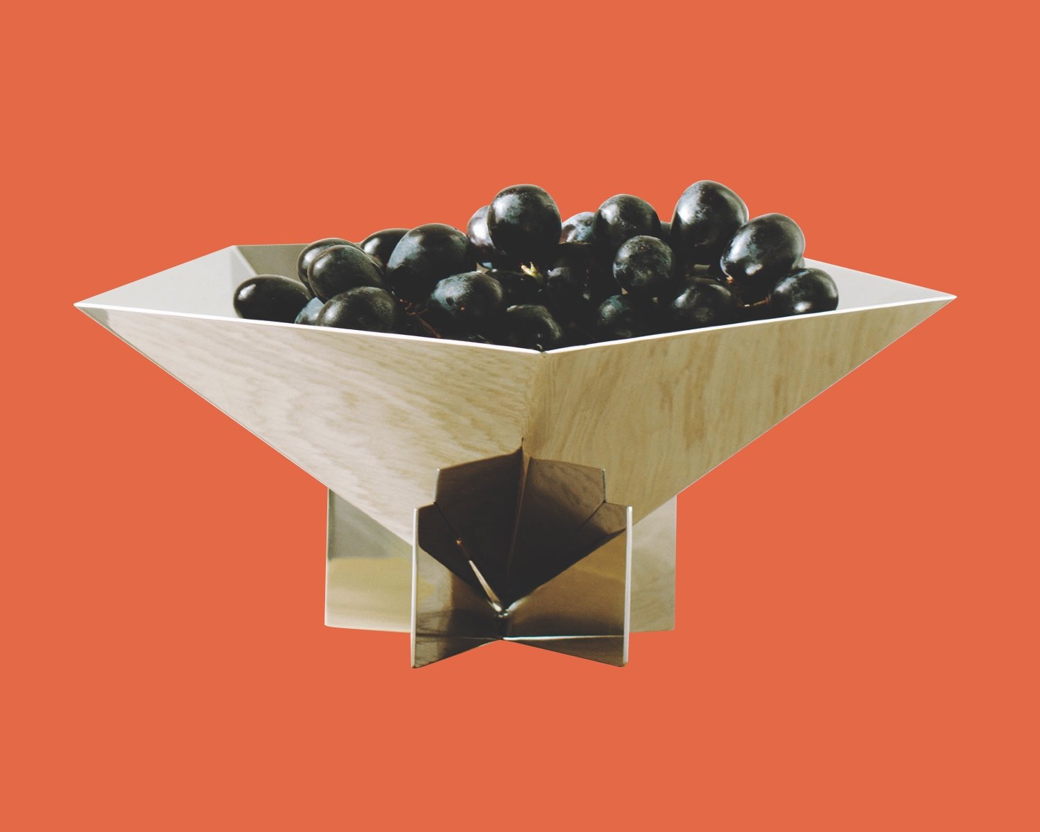 One of Azure's top gifts for architects from our 2024 guide is this angular steel fruit bowl shown with a pile of grapes.