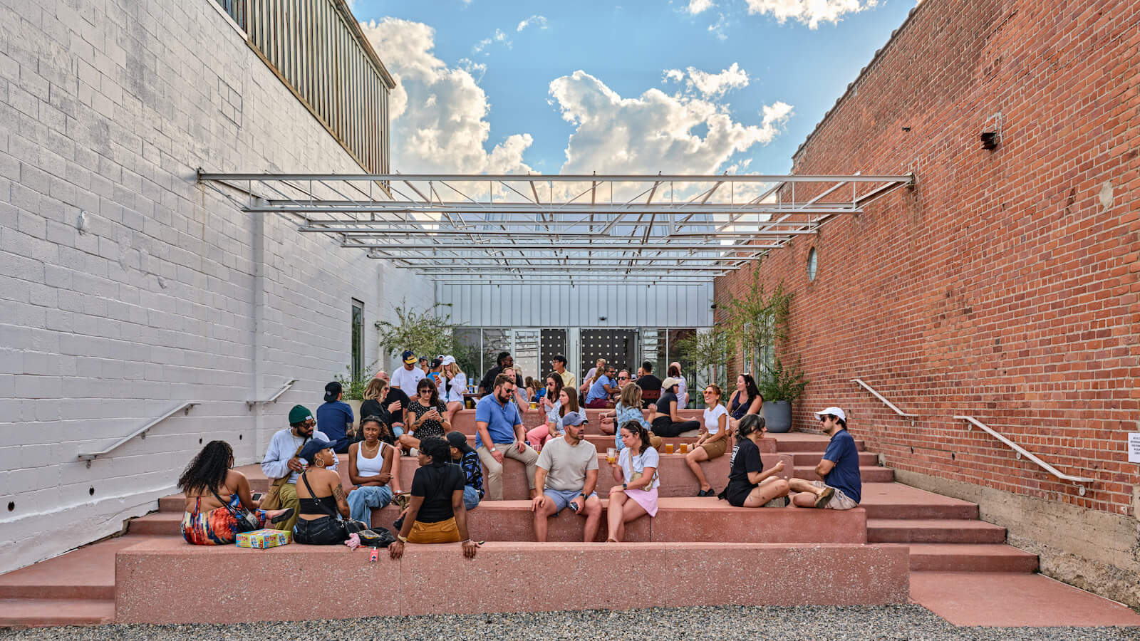 Crowd gathered at the steps of Collect Beer Bar at the Lantern building in Little Village Detroit