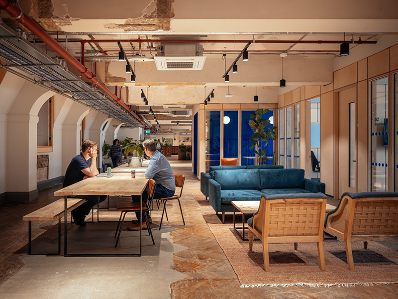 Climate-tech companies make use of the many informal work areas throughout the office, including this multi-use zone outside the royal blue Ideas Lab.