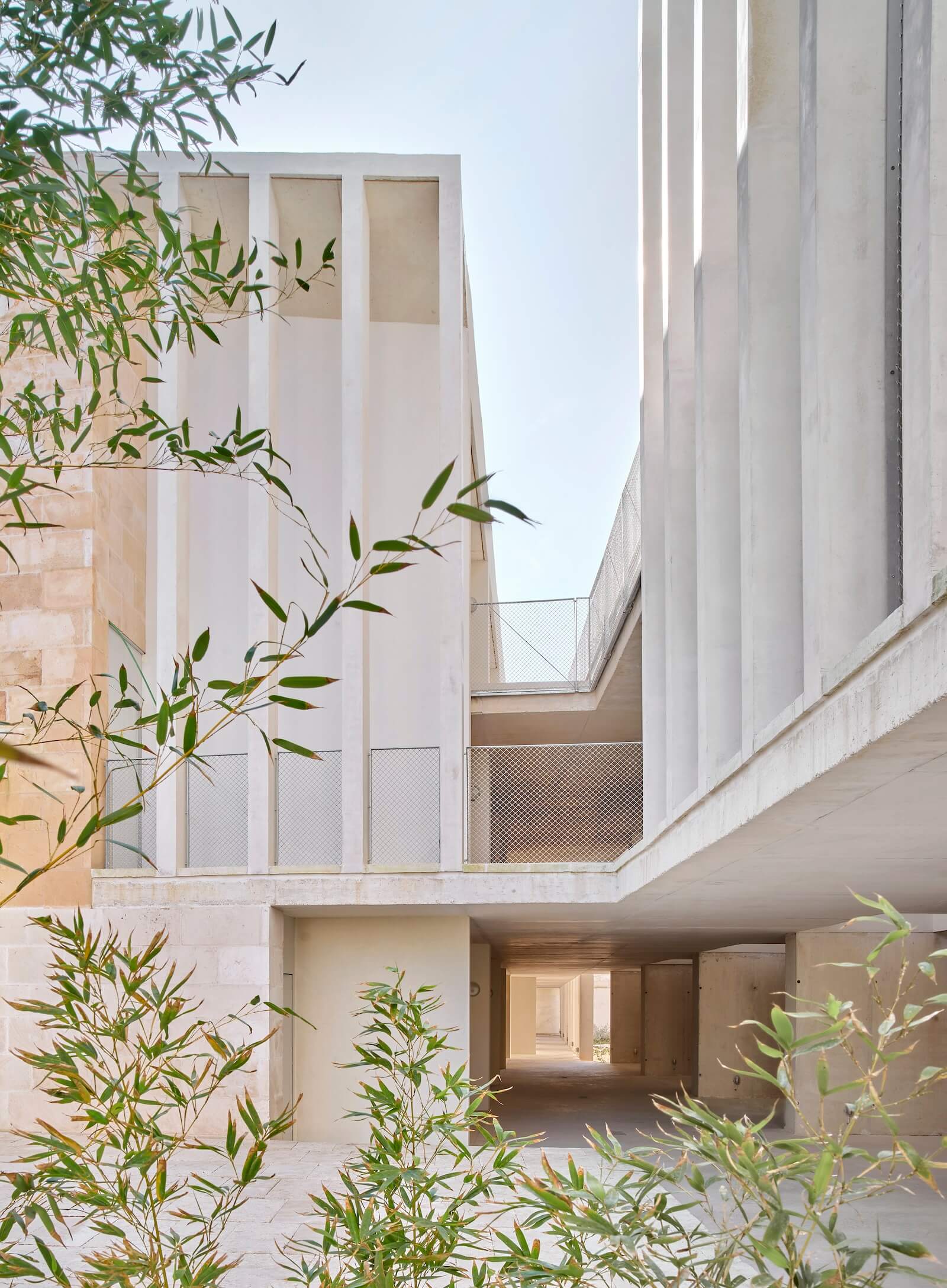 On the upper levels of Peris+Toral's housing in Son Servera, the common streets are delineated with vertical slats coupled with metal mesh barriers. The walkways are finished with cork ETICS clad in lime plaster.