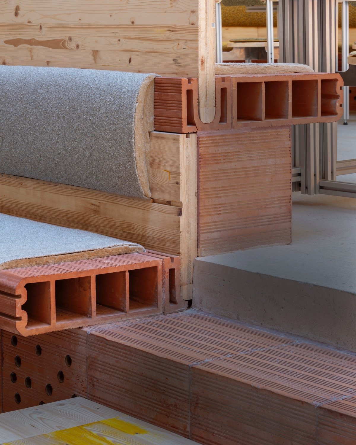 A closeup of the seating at Tramo restaurant in Madrid, showing a bench built into a partition built from plywood and perforated clay brick modules.