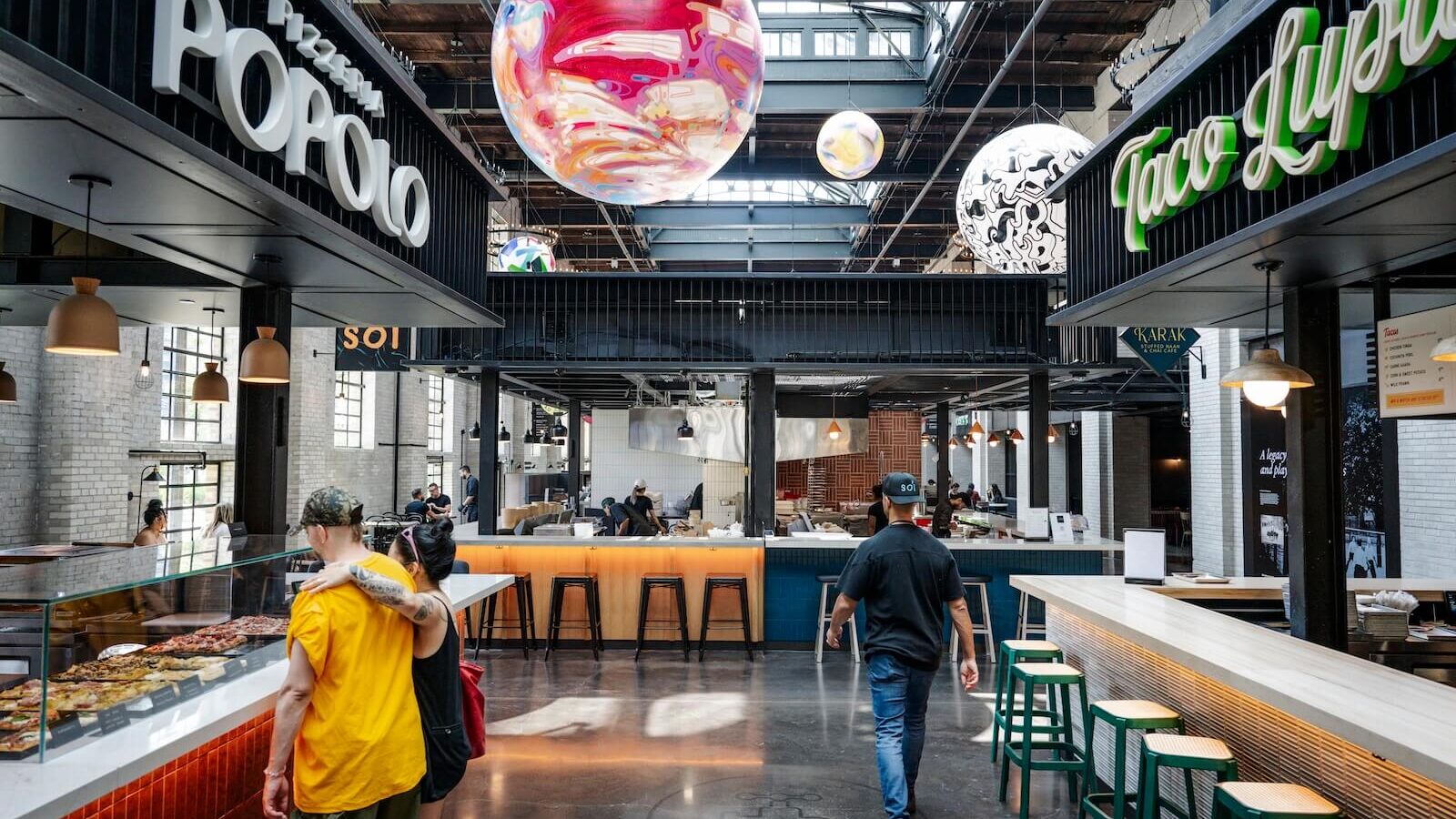 Toronto-based multidisciplinary artist Jacquie Comrie created the colourful swirl of a planet that hangs in the skylit space between Pizzeria Popolo and Taco Lupita at Toronto's Waterworks Food Hall.